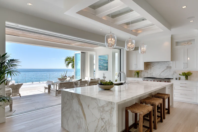 Coastal kitchen with wicker bar stools and skylight - white quartz island